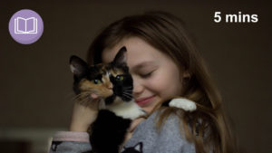 young girl hugging cat